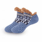 Nordic Knit Slipper Socks in Hellblau, gestrickte Hüttensocken mit Sherpa-Bündchen vor weißem Hintergrund