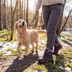 Pessoa com Warm Comfort Shoes a passear o cão num trilho com neve
