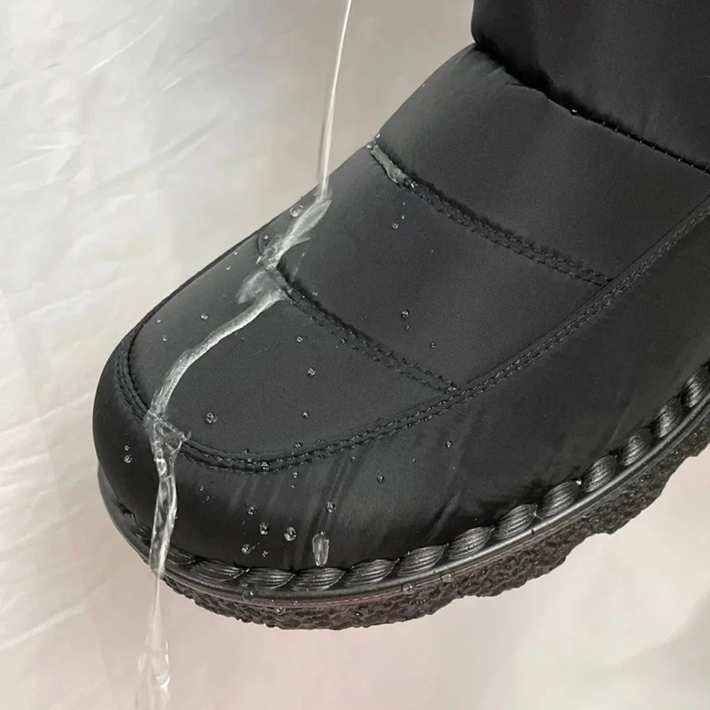 Primo piano di gocce d'acqua che scivolano su un Waterproof Comfort Boot nero