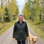 Kvinna i ljusgrå Classic Waffle Beanie promenerar med golden retriever i höstig björkskog