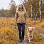 Kvinde i khakifarvet Utility Softshell Jacket på gåtur med en golden retriever