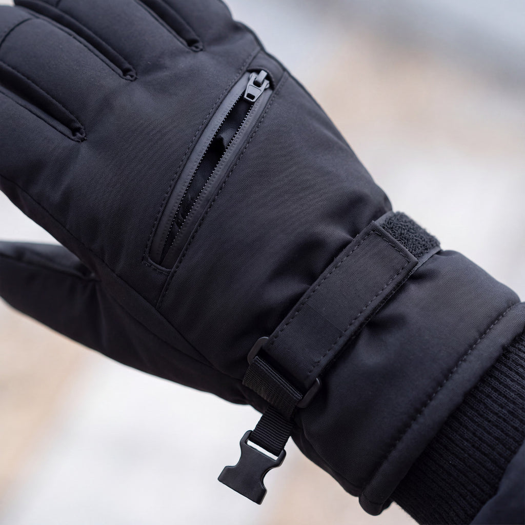 Nahaufnahme der Reißverschlusstasche und des Klettbands am schwarzen Skihandschuh