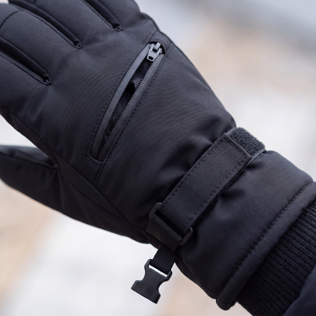 Nahaufnahme der Reißverschlusstasche und des Klettbands am schwarzen Skihandschuh